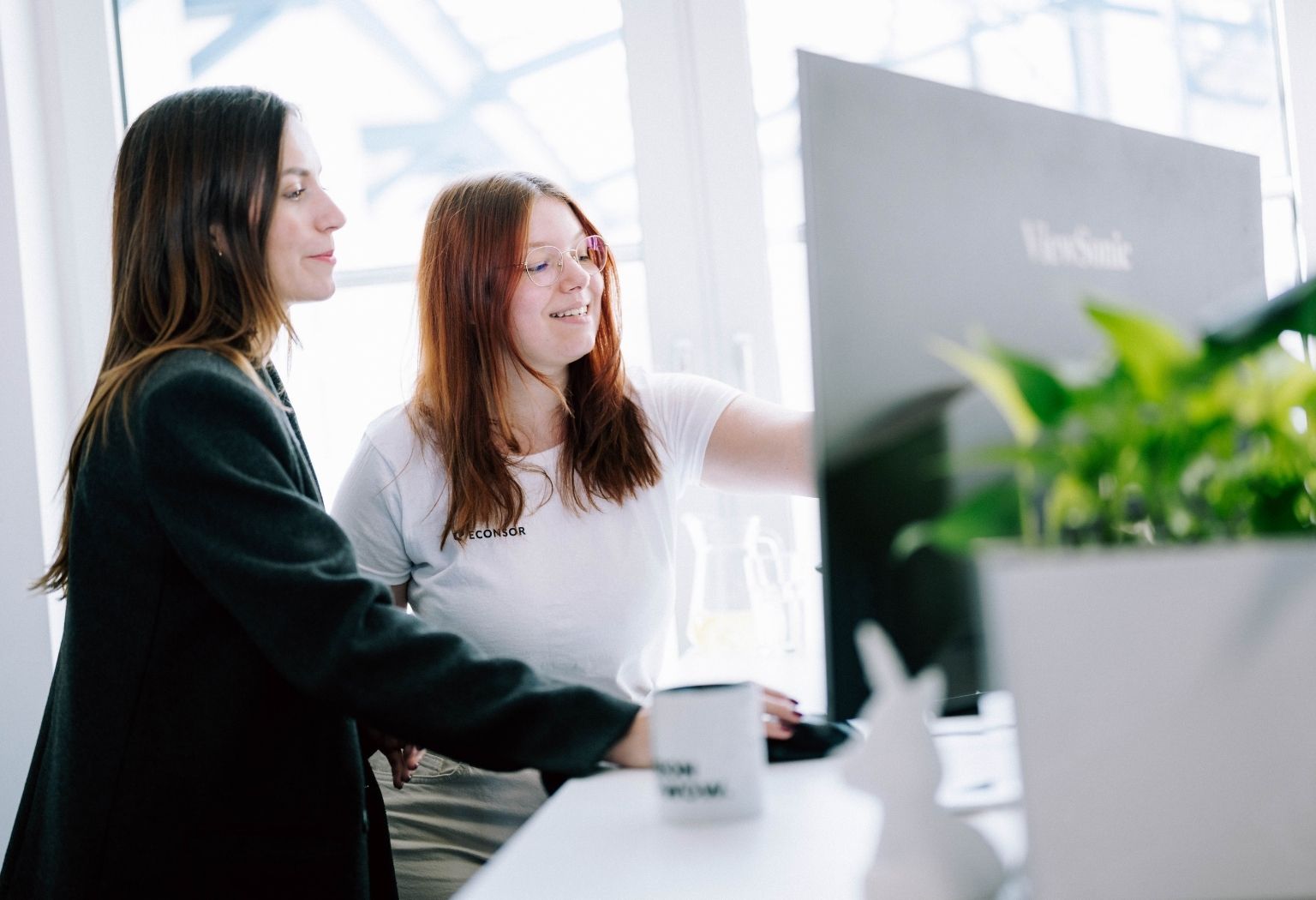 Online-Marketing-web Zwei Frauen analysieren einen Computerbildschirm, der Informationen zu Online-Marketing zeigt.