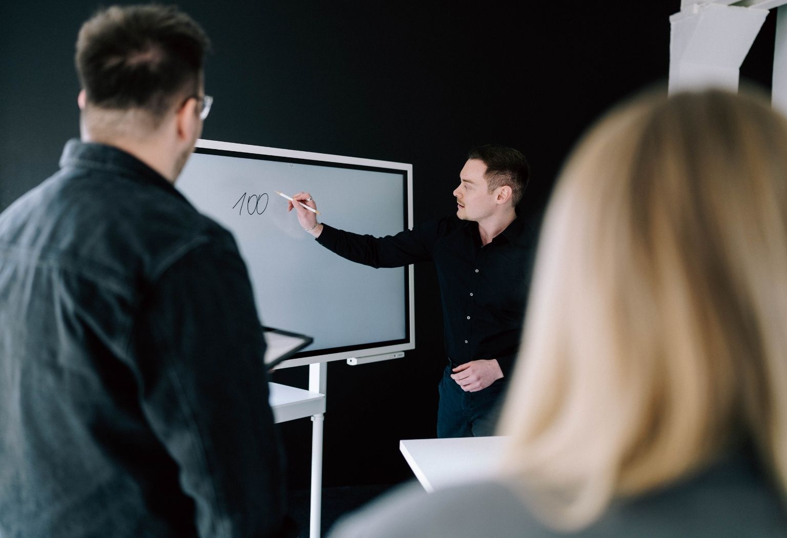 Suchmaschinenoptimierung Ein Mann steht vor einem Whiteboard und präsentiert Informationen zur Suchmaschinenoptimierung.